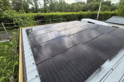 Zwarte zonnepanelen op een hellend dak, strak in lijn gelegd.